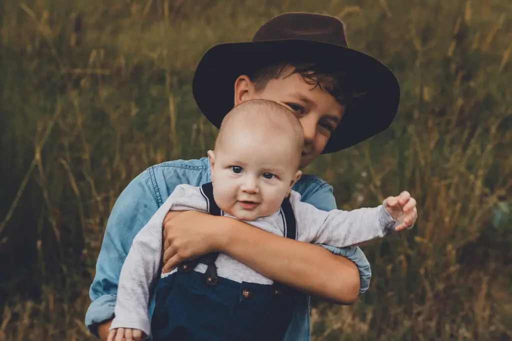 Boy with his baby brother in a field